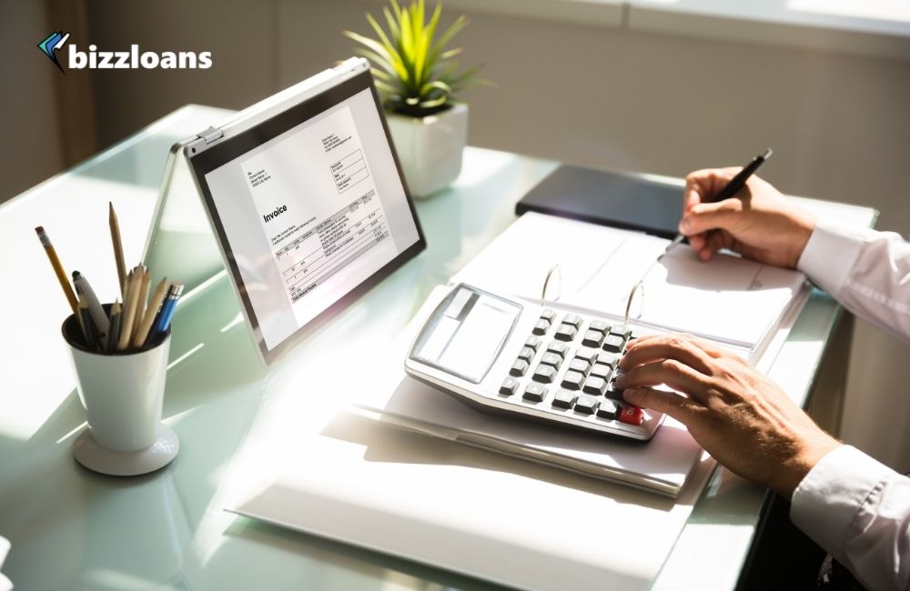 Businessman calculating invoice using calculator for his business expansion funding