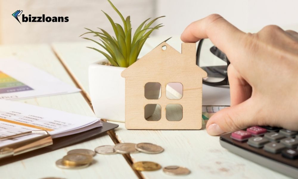 man's hand touching a miniature of a house as a collateral to his small business loan