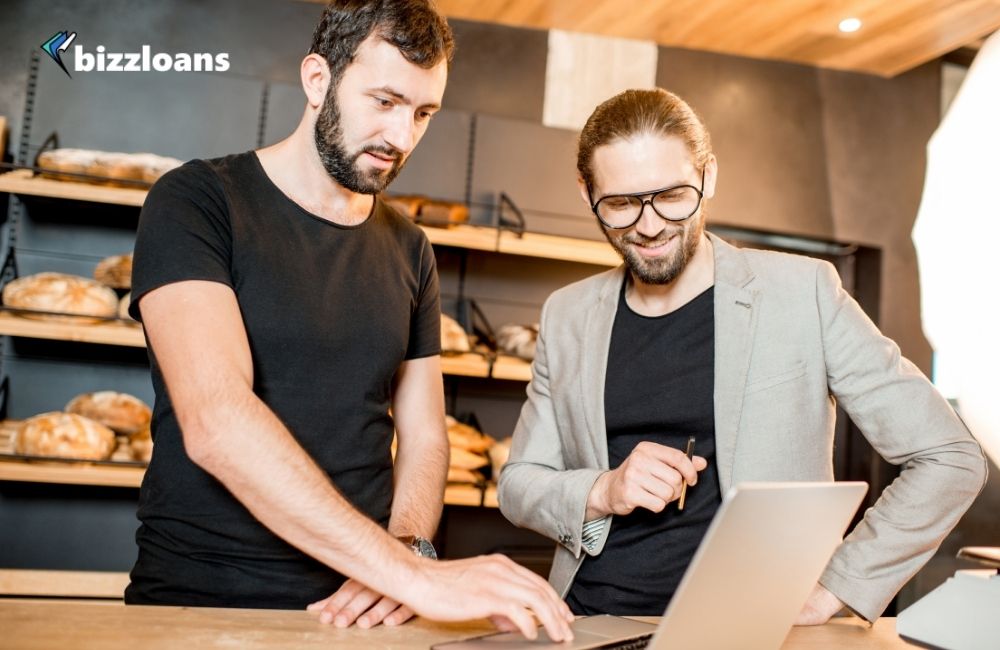 two business owners looking at a laptop using ai for their small business