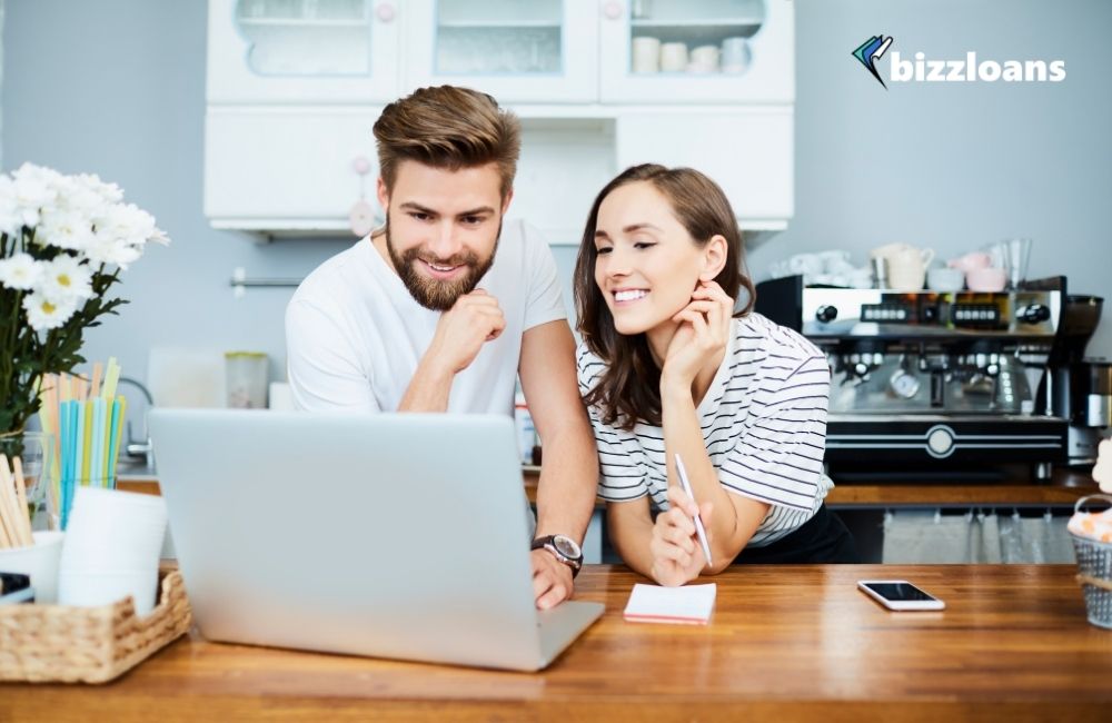 happy couple using a financial tool for their business on a laptop