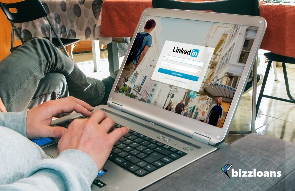 hands of a business owner using a laptop displaying LinkedIn login page