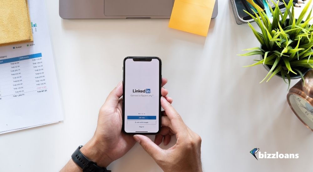 hand holding a smartphone displaying LinkedIn as his marketing strategy