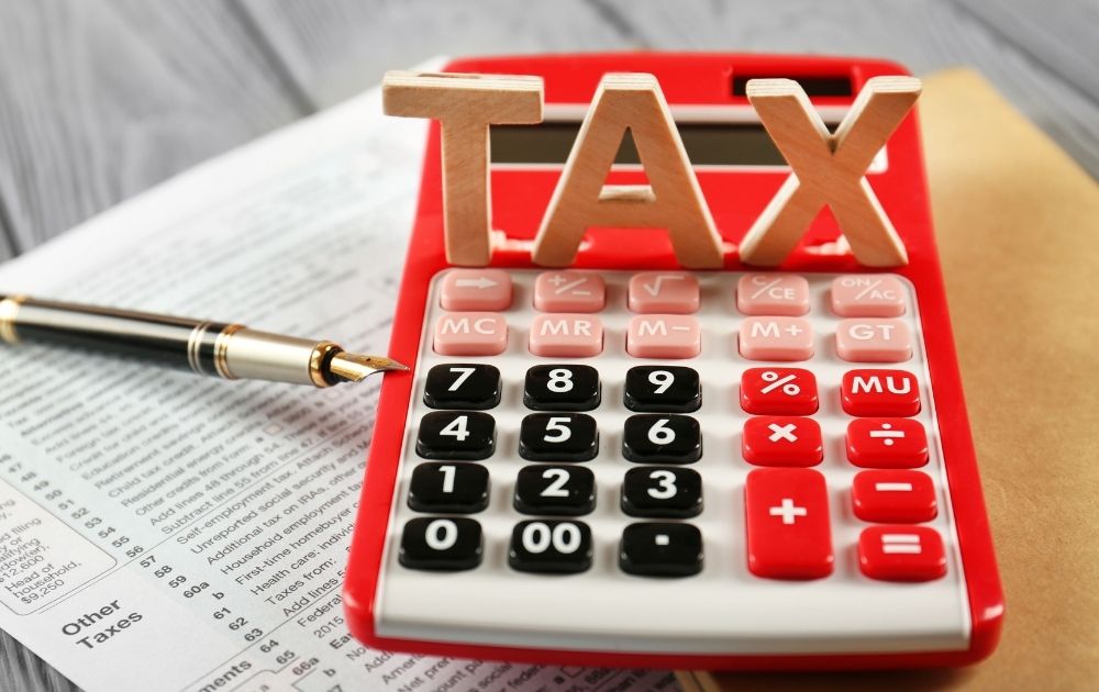 Word TAX and Calculator on Wooden Table