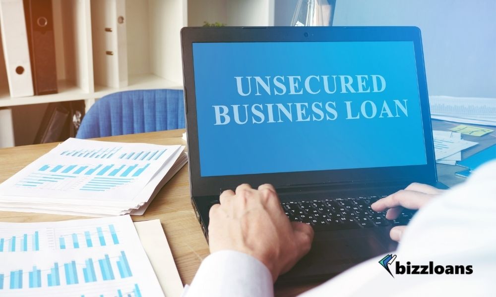 hands of a business owner using a laptop displaying unsecured business loan