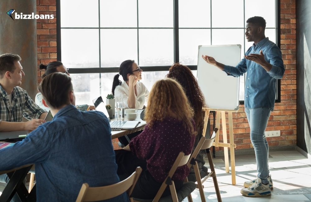 Male leader lecturing his employees in office; leadership skill concept