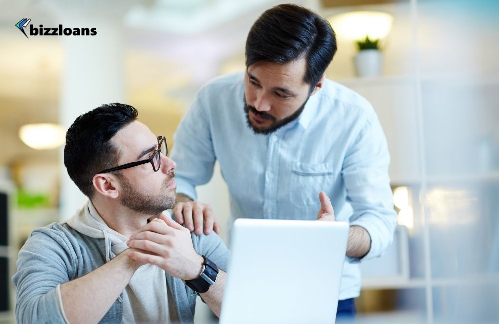 business owner talking to his staff in front of laptop