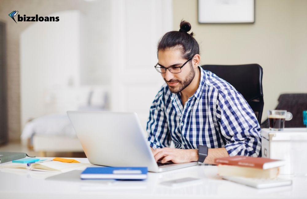 business owner looking at his credit score on laptop in his office