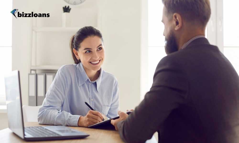 smiling loan broker talking to a client who is getting a business loan