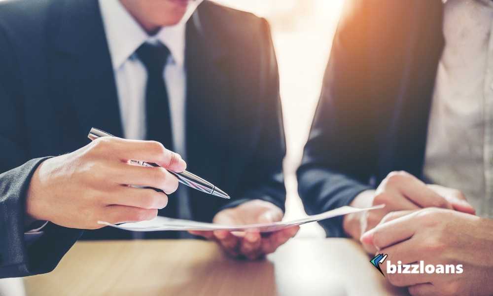 two business people discussing about cash flow lending with paper and pen on hand