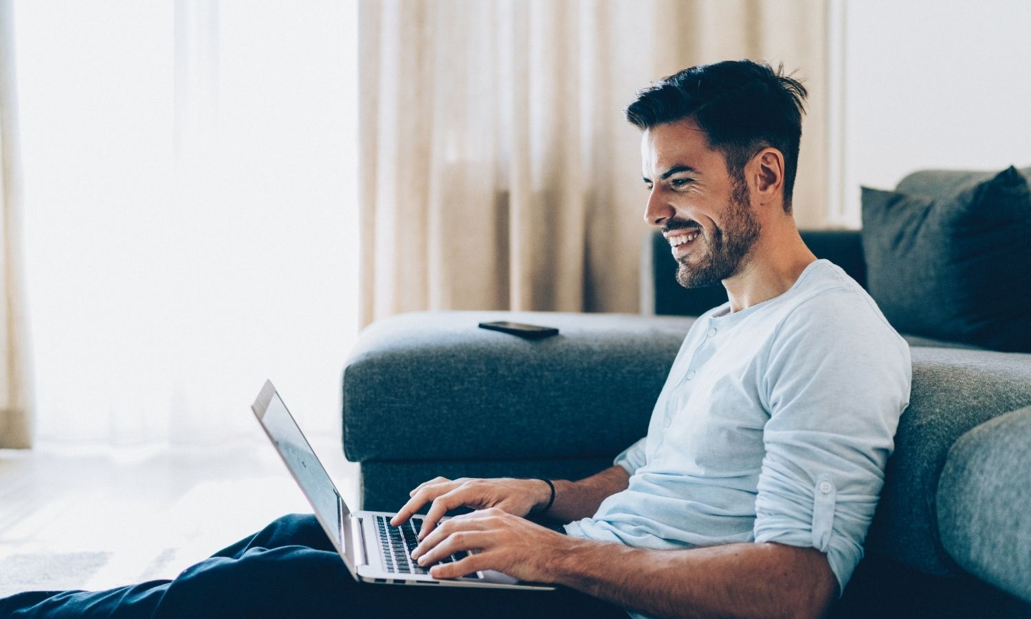 happy male business owner searching for unsecured small business loans on laptop