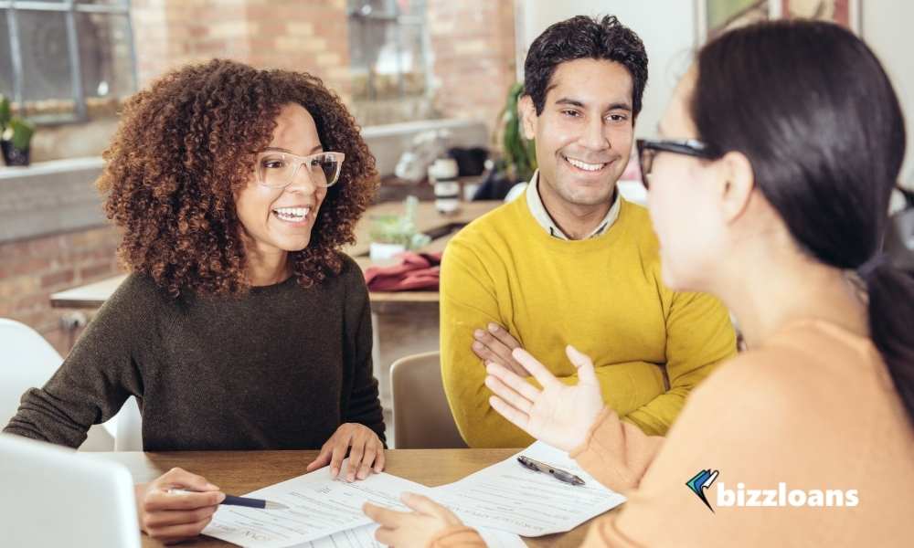 two business owners about to sign a business loan contract with no personal guarantee with an agent