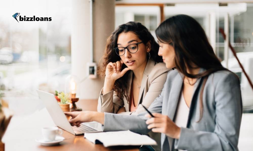 business owners discussing with laptop in a coffee shop