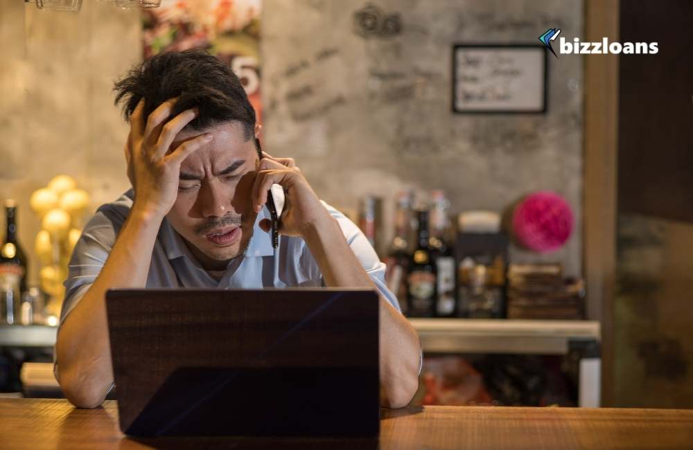 stressed restaurant business owner in front of his laptop