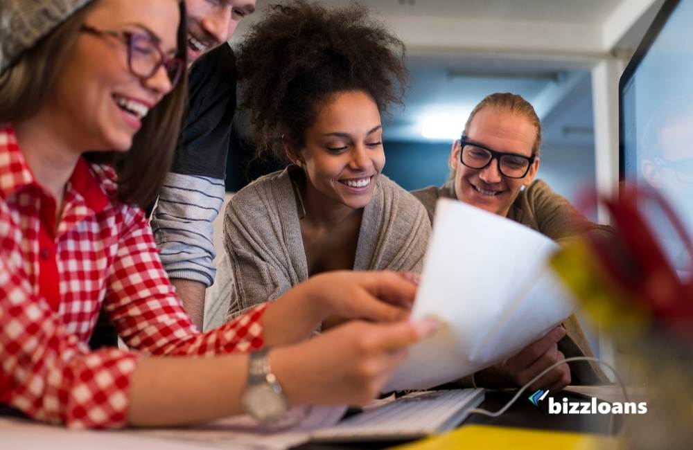 group of happy employees reading a document