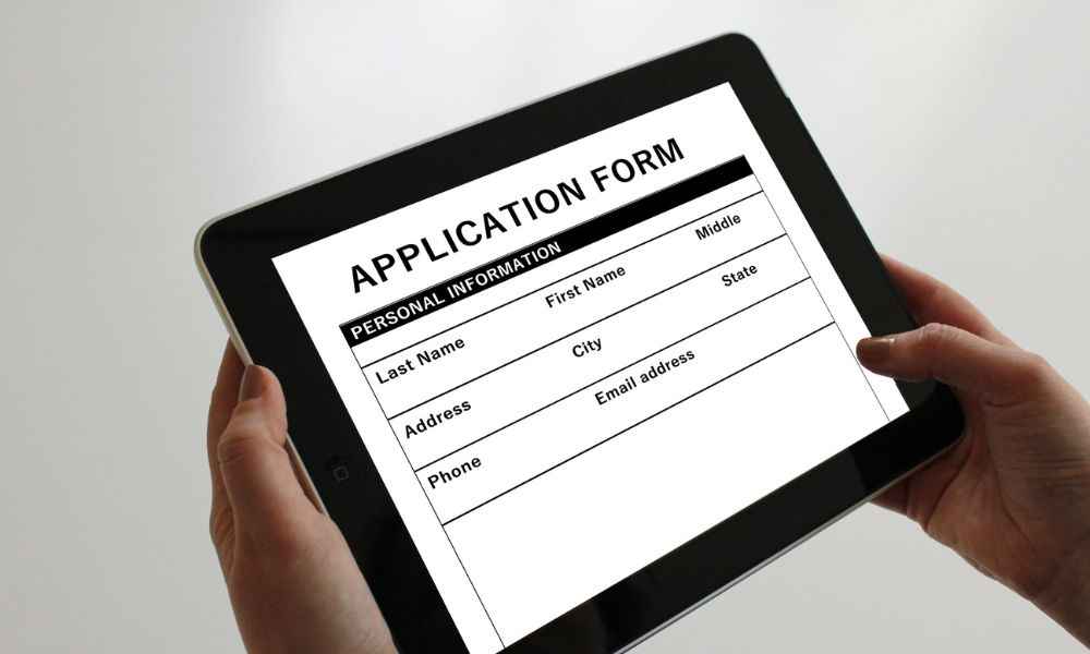 Hands Holding Tablet With loan Application Form