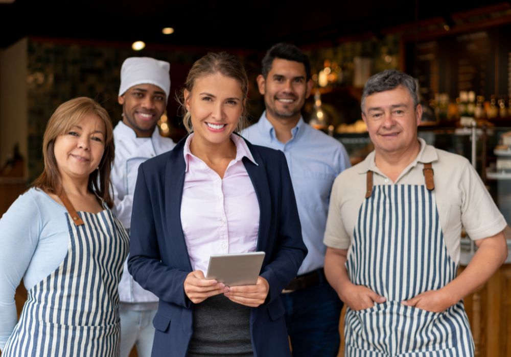 Happy business owner at a restaurant with her staff