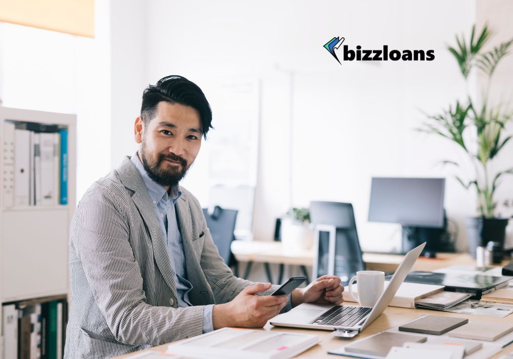 happy business owner on laptop; business loan concept